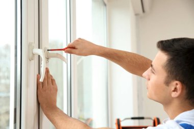 Genç bir işçi düz içinde pencere tamiri