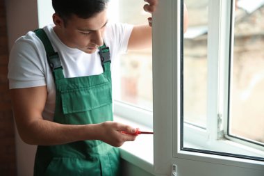 Genç bir işçi düz içinde pencere tamiri