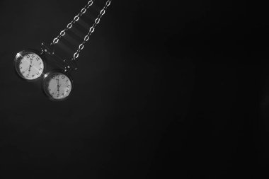 Koyu arka plan üzerinde sallanan cep saati. Hipnoz kavramı