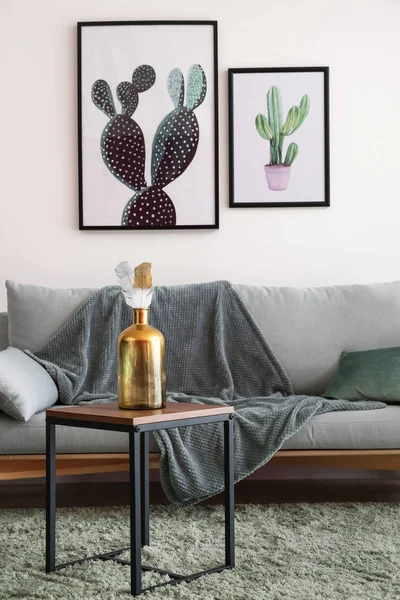 Table with golden bottle in interior of living room — Stock Photo, Image