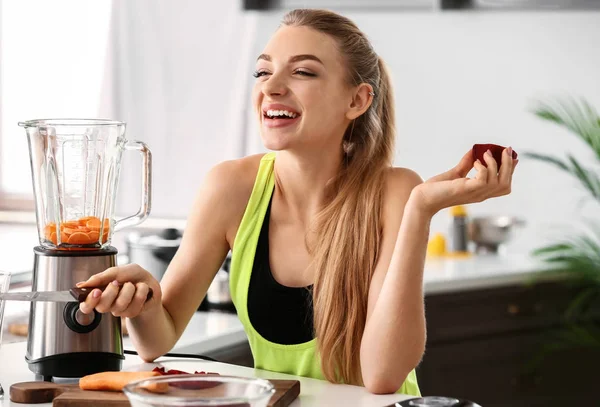 Jovem mulher fazendo smoothie saudável em casa — Fotografia de Stock