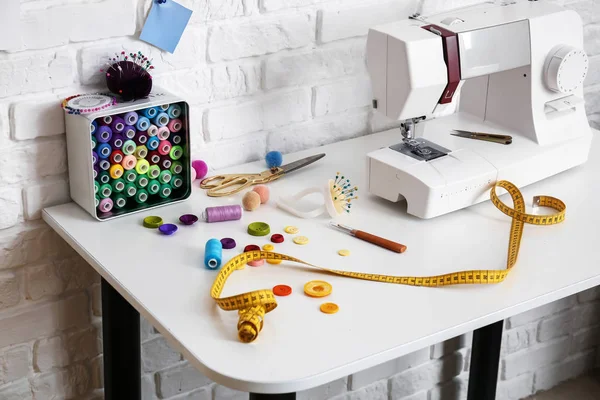 Accessoires met naaimachine op de kleermaker werkplek in atelier — Stockfoto