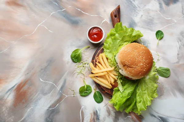 Sabrosa hamburguesa y papas fritas en la mesa — Foto de Stock