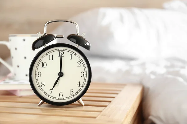 Alarm clock on table in bedroom — Stock Photo, Image