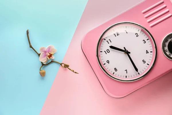 Relógio e bela flor no fundo de cor — Fotografia de Stock