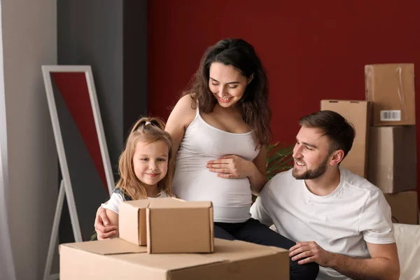 Happy family expecting baby with belongings at new home — Stock Photo, Image