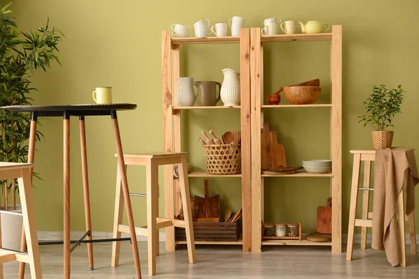 Set van schone gerechten met gebruiksvoorwerpen op houten planken in keuken — Stockfoto
