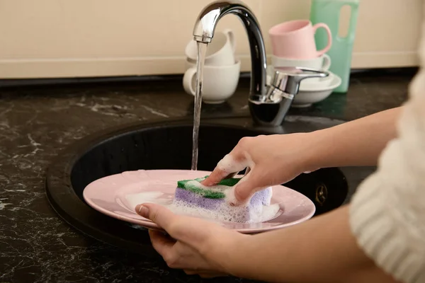 Woman washing plate in kitchen sink — Stock Photo, Image