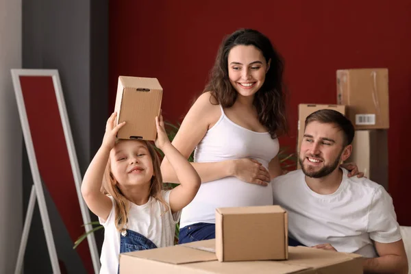 Happy family expecting baby with belongings at new home — Stock Photo, Image
