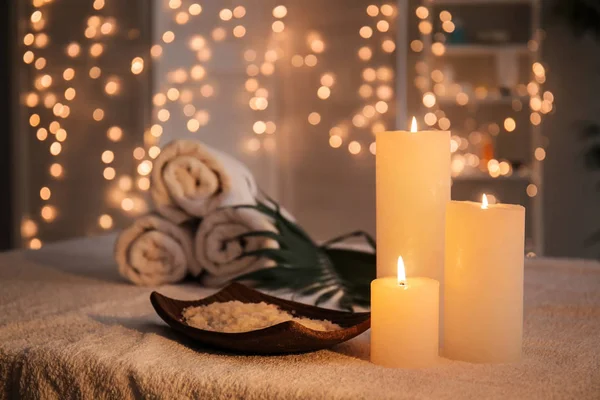 Teller mit Meersalz und brennenden Kerzen auf dem Tisch im Wellness-Salon — Stockfoto