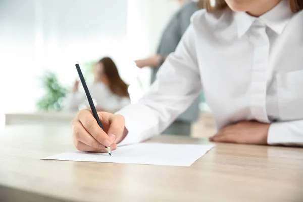 Flicka som passerar skolan test i klassrummet — Stockfoto