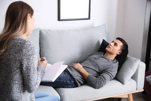 Psychologue féminine travaillant avec une patiente allongée sur un canapé dans son bureau — Photo