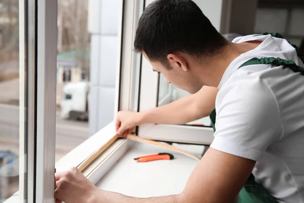 Młodego pracownika instalacja okna w mieszkaniu — Zdjęcie stockowe