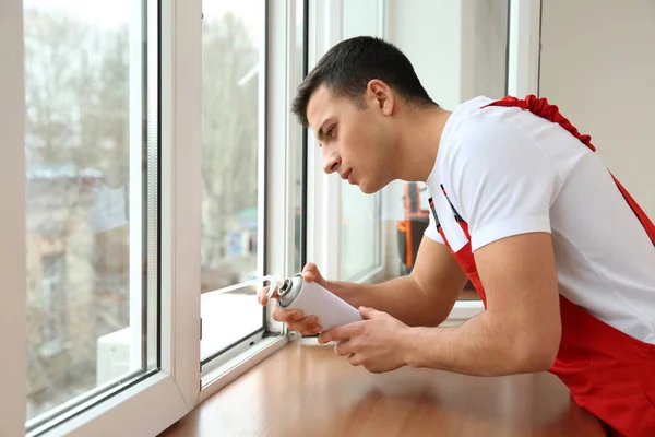 Trabajador joven instalando ventana en piso —  Fotos de Stock