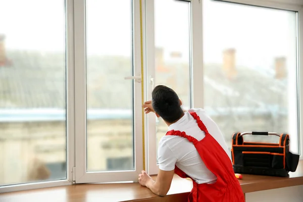 Młodego pracownika wykonywania pomiarów okna w mieszkaniu — Zdjęcie stockowe
