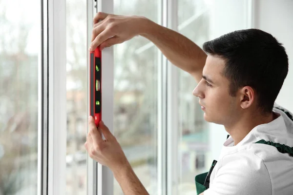 Giovane lavoratore riparazione finestra in appartamento — Foto Stock