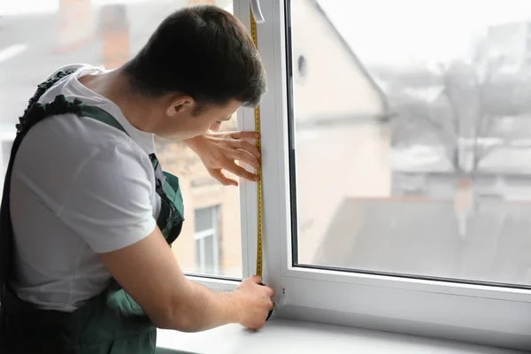 Hombre trabajador tomando medidas de ventana en plano — Foto de Stock