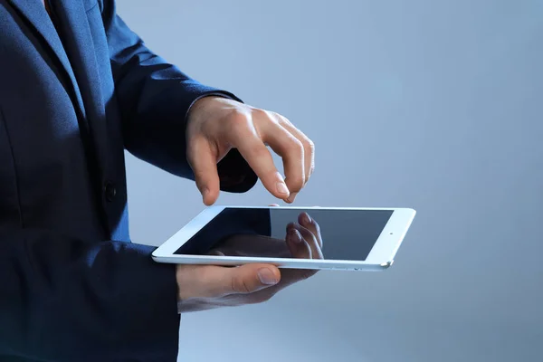 Empresario con Tablet PC sobre fondo de color — Foto de Stock