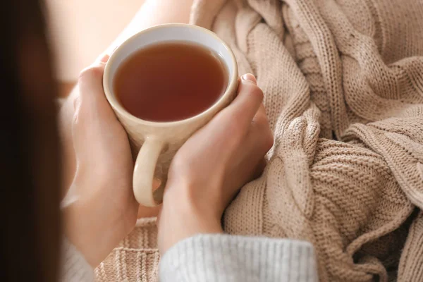 Молодая женщина пьет горячий чай дома, крупным планом — стоковое фото