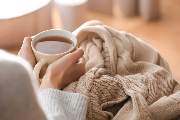 Mujer joven bebiendo té caliente en casa, primer plano — Foto de Stock