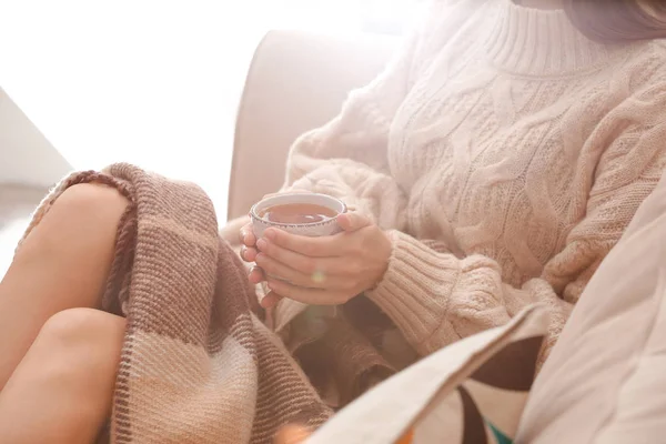 Mujer joven bebiendo té caliente en casa, primer plano — Foto de Stock