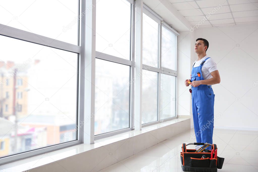 Young worker in room with big windows