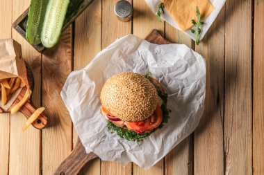 Lezzetli burger ve malzemeler ahşap arka plan üzerinde