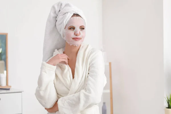 Mulher bonita com máscara facial folha em casa — Fotografia de Stock