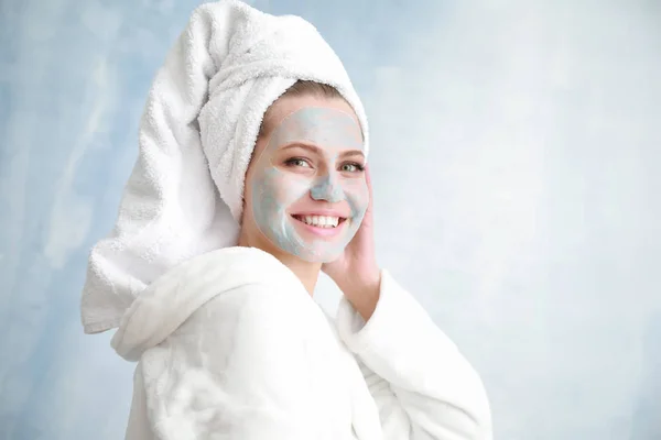 Mooie jonge vrouw met masker op lichte achtergrond — Stockfoto