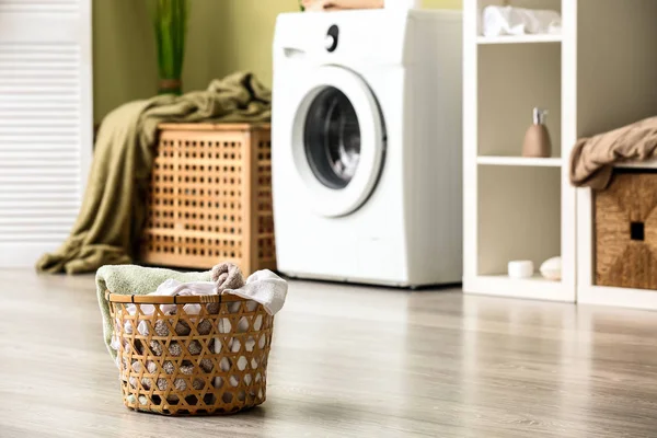 Basket with dirty laundry on floor in bathroom