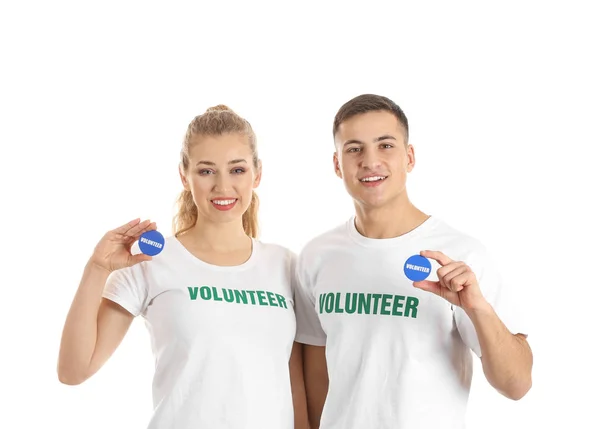 Young volunteers with badges on white background — Stock Photo, Image
