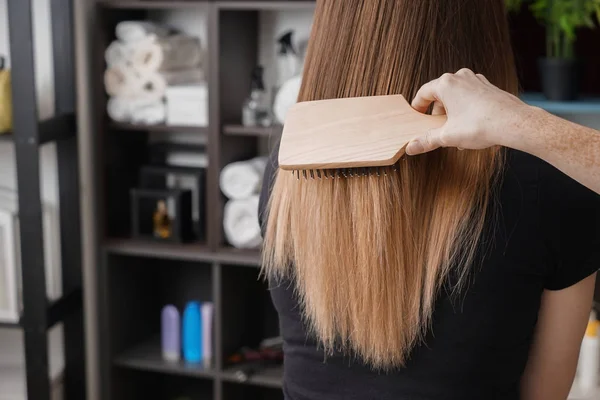 Kapsalon poetsen lang haar van jonge vrouw in salon — Stockfoto