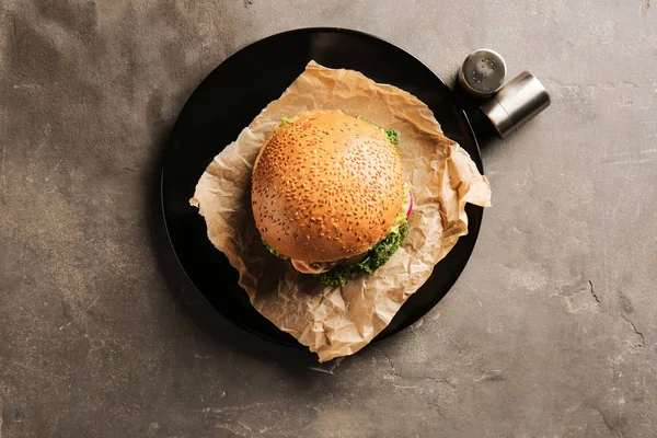 Plate with tasty burger on grey background — Stock Photo, Image