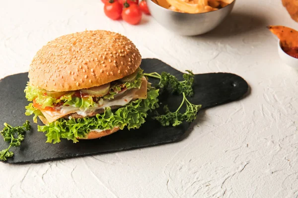 Tasty burger on slate board — Stock Photo, Image
