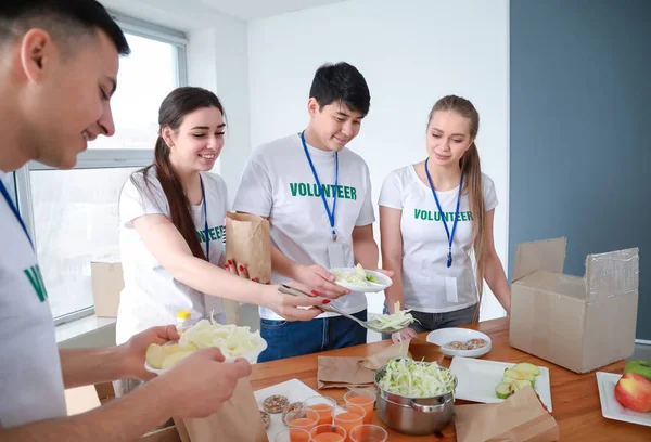 Junge Freiwillige mit Lebensmitteln für arme Menschen im Haus — Stockfoto