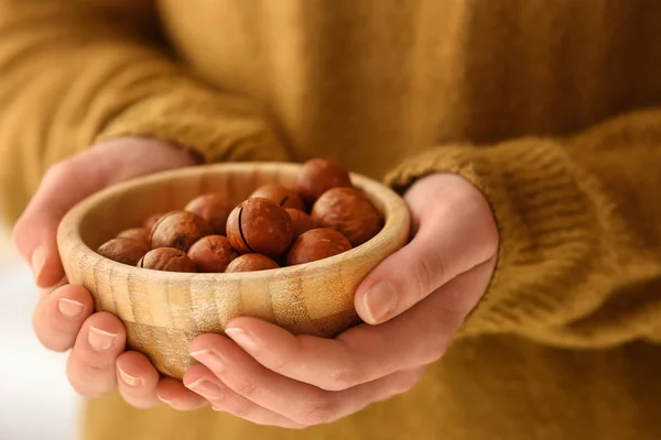 Donna che tiene ciotola con noci di macadamia, primo piano — Foto Stock