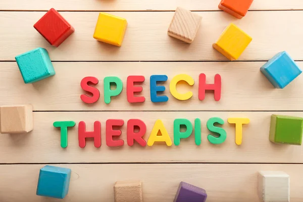 Cubes and text SPEECH THERAPIST on wooden background — Stock Photo, Image