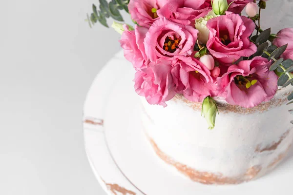 甜蜜的蛋糕与花卉装饰在浅色背景, 特写镜头 — 图库照片