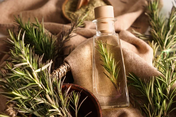 Fles met rozemarijnolie op tafel — Stockfoto