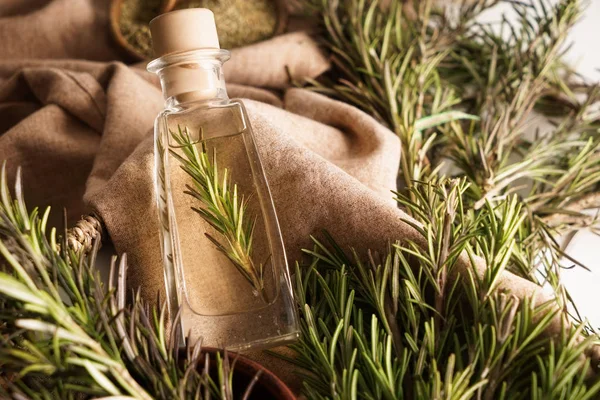 Bottle with rosemary oil on table — Stock Photo, Image