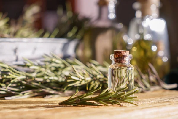 Botella con aceite de romero en la mesa —  Fotos de Stock