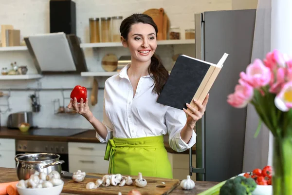 Hermosa mujer leyendo nuevas recetas en la cocina en casa —  Fotos de Stock