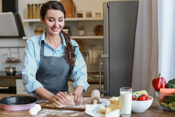 Beautiful woman making dough in kitchen at home — Stock Photo, Image