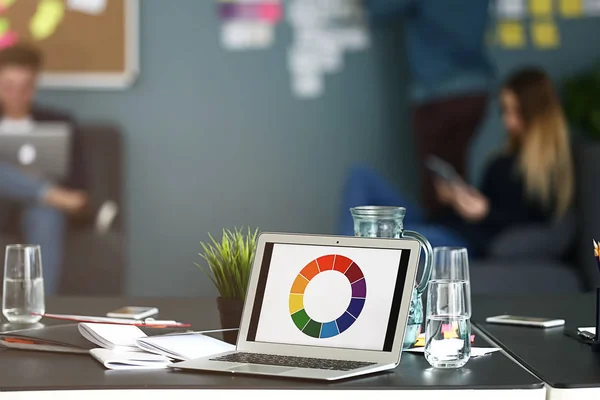 Table with laptop in modern office of IT company — Stock Photo, Image