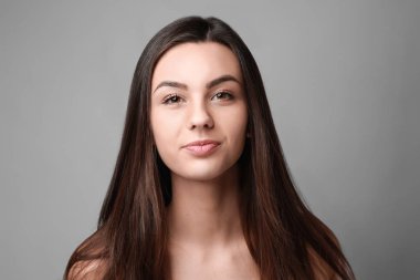 Gri arka plan üzerinde sağlıklı cilt ile güzel bir kadın portresi