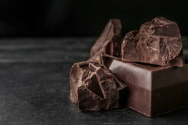 Bucăți de ciocolată gustoasă pe fundal întunecat — Fotografie, imagine de stoc