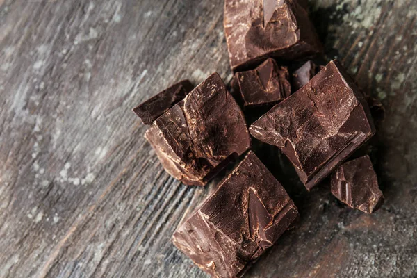 Kawałki smaczny gorzkiej czekolady na podłoże drewniane — Zdjęcie stockowe