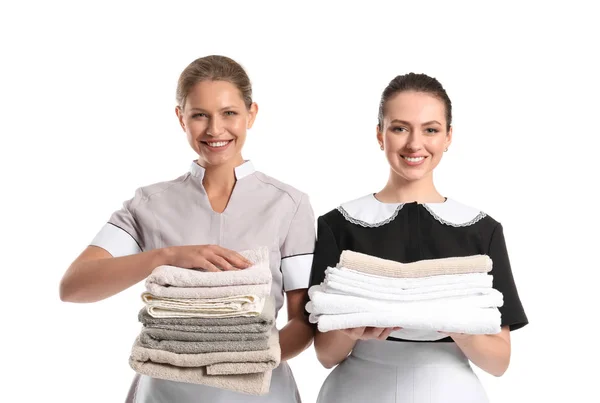 Portrait of beautiful female housekeepers with clean towels on white background — Stock Photo, Image