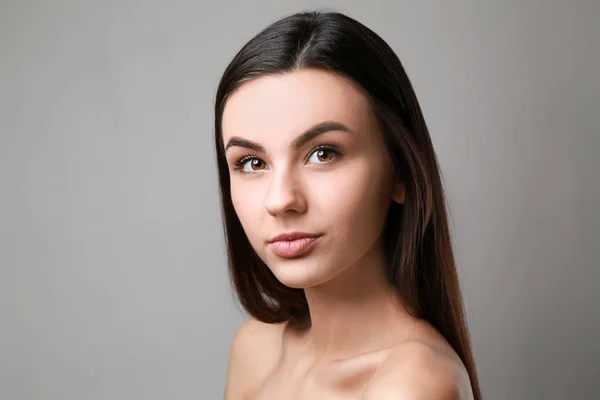 Portrait de belle femme avec une peau saine sur fond gris — Photo