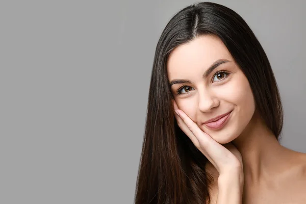 Portrait of beautiful woman with healthy skin on grey background — Stock Photo, Image